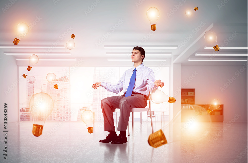 young businessman meditating in the office