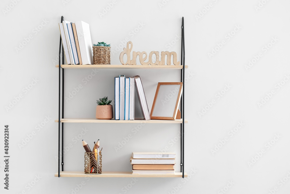 Stylish shelf hanging on light wall