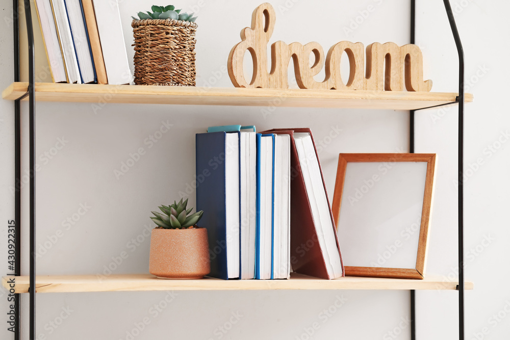 Stylish shelf hanging on light wall