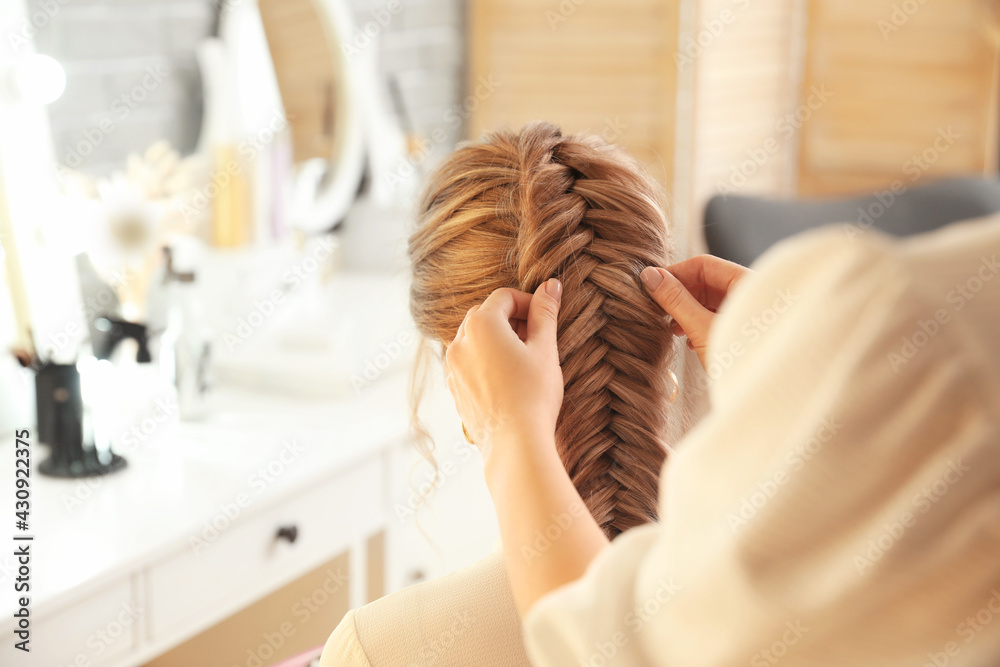 Hairdresser working with client in beauty salon