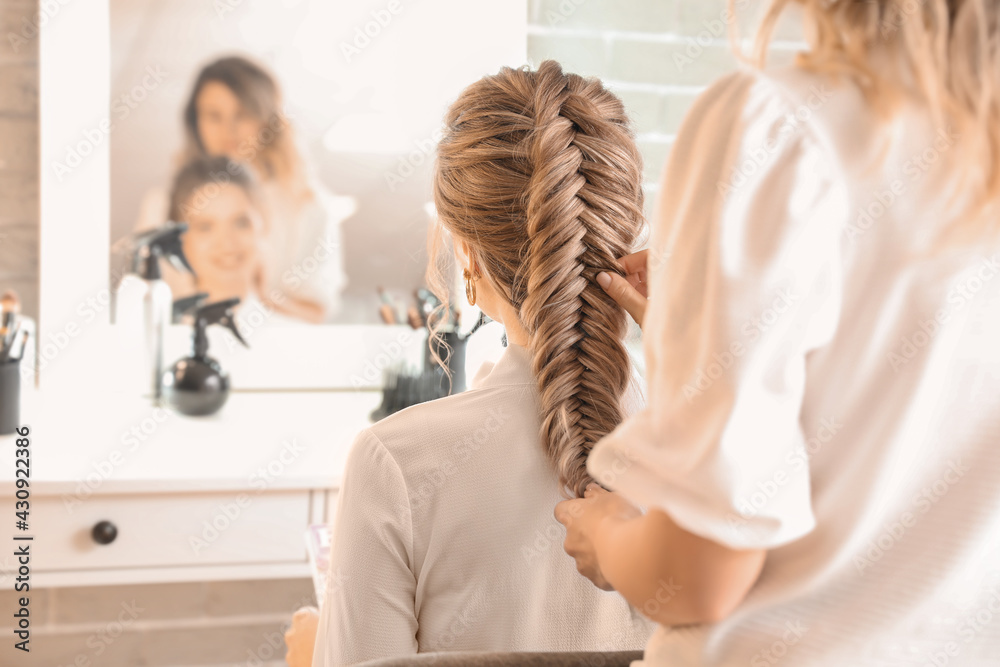 Hairdresser working with client in beauty salon