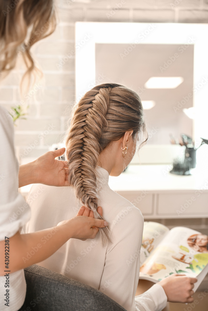 Hairdresser working with client in beauty salon