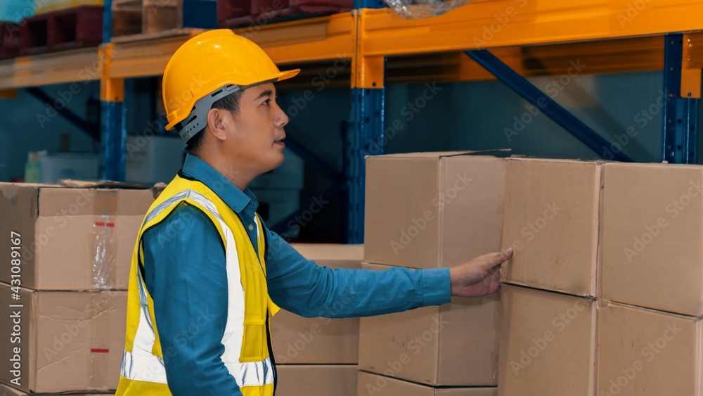 Asian warehouse worker checking packages in storehouse . Logistics , supply chain and warehouse busi