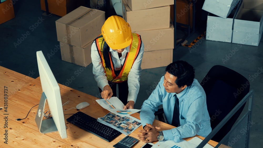 Warehouse manager and worker working in the storehouse . Logistics , supply chain and warehouse busi