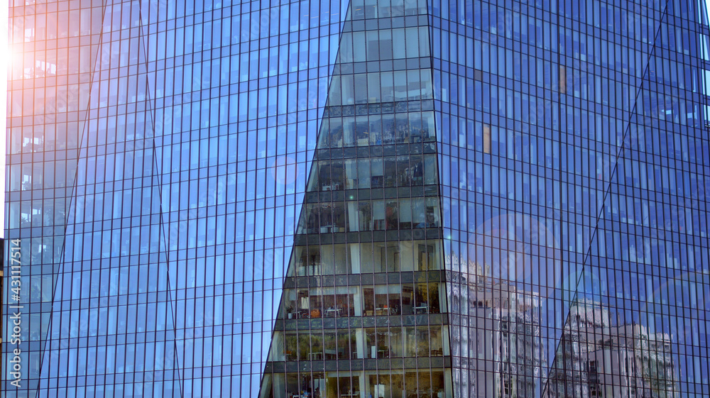 A fragment of the steel and glass metal facade of office building. Detail architecture steel and gla