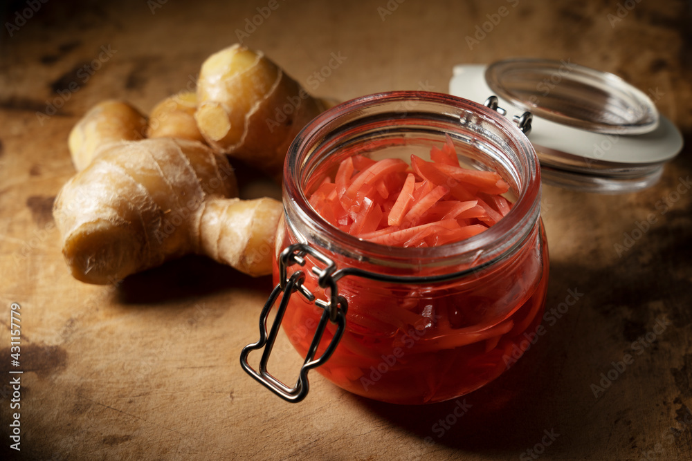 Red pickled ginger placed on an old wooden background.