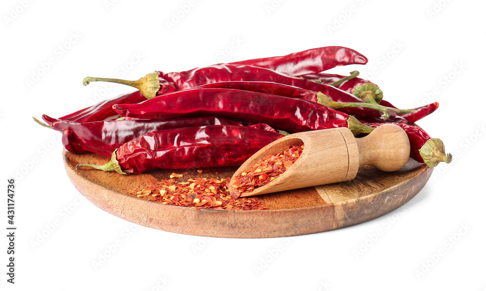 Board with dry chili peppers on white background