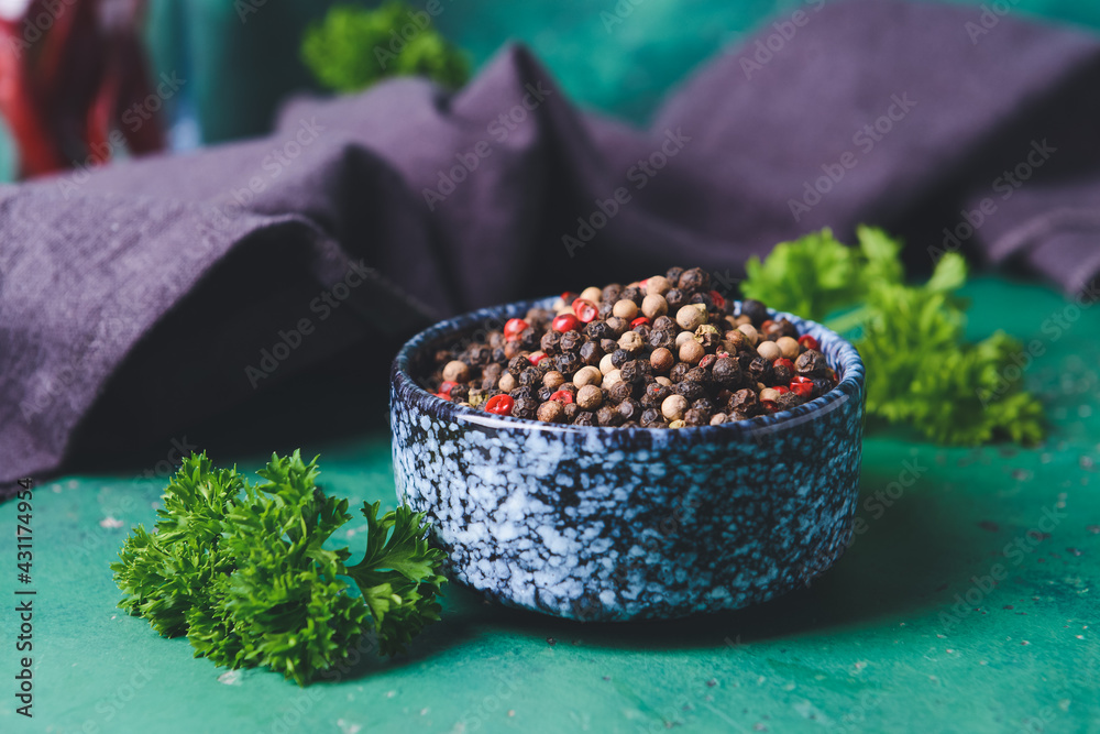 Bowl with peppercorns on color background