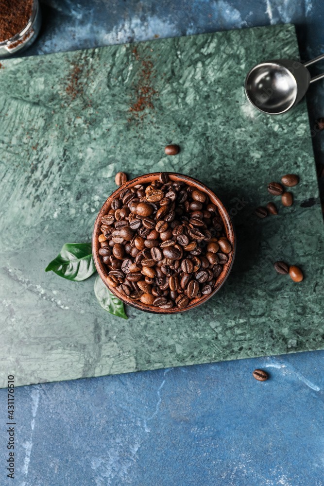 Bowl with coffee beans on color background