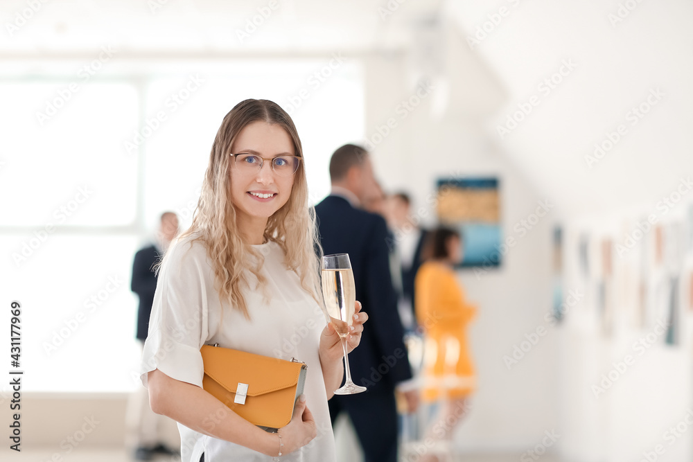 年轻女子在现代美术馆的展览上喝香槟