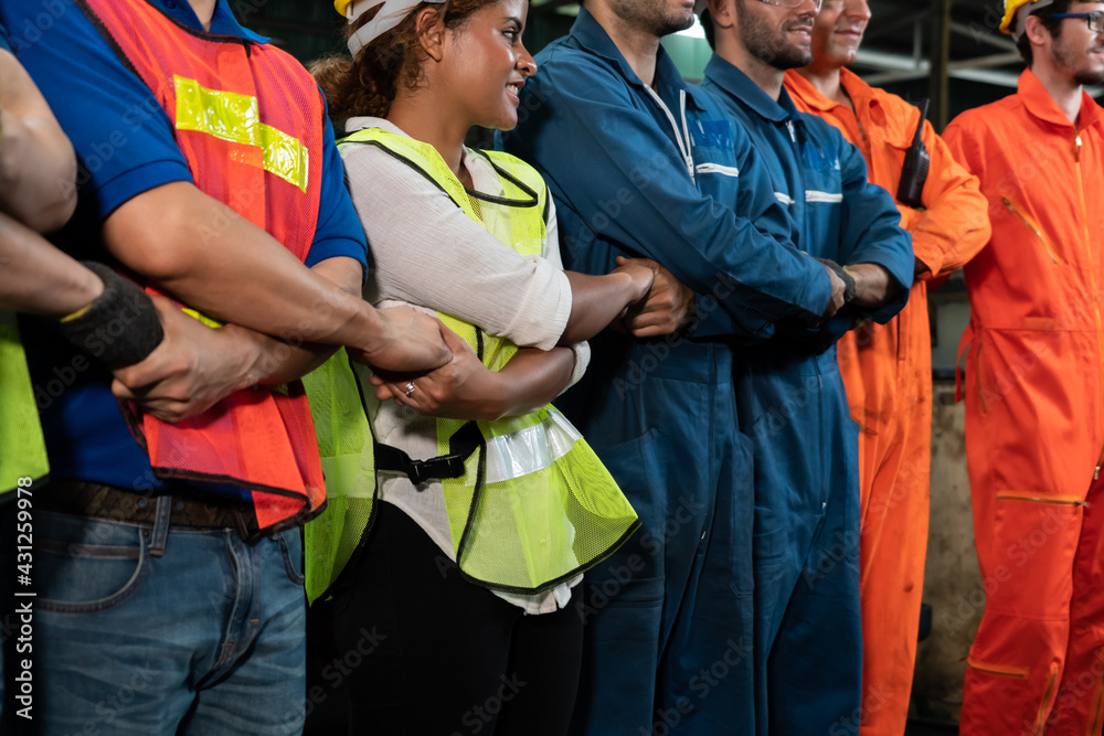 Skillful worker stand together showing teamwork in the factory . Industrial people and manufacturing