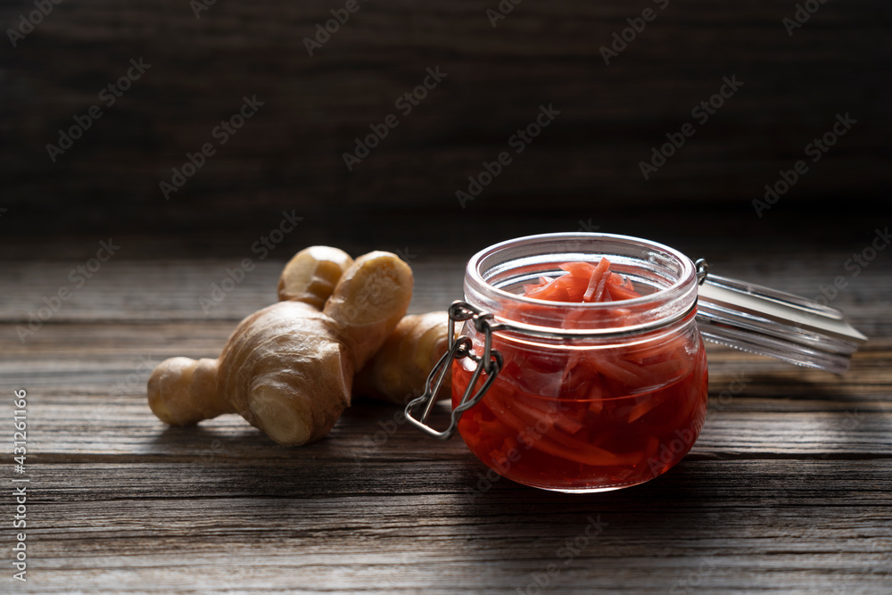 Red pickled ginger placed on an old wooden background.