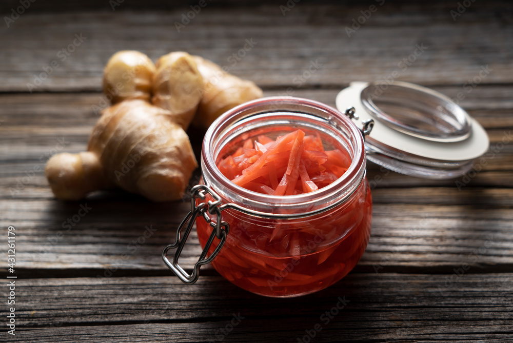 Red pickled ginger placed on an old wooden background.