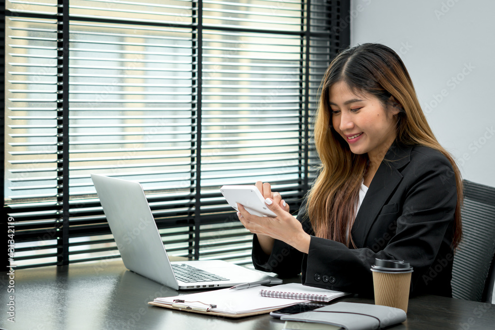 Smiling young manager working on promising project with help of laptop while sitting at modern offic