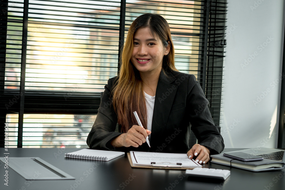 Smiling young manager working on promising project with help of laptop while sitting at modern offic