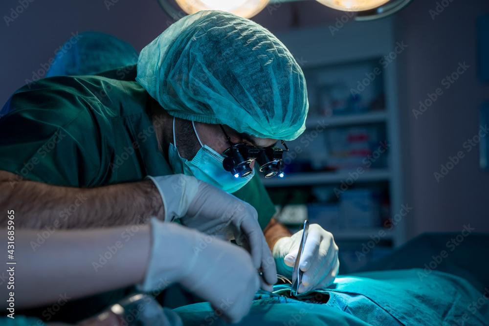 Team of professional surgeons and nurses suture wound after successful surgery in surgery room.