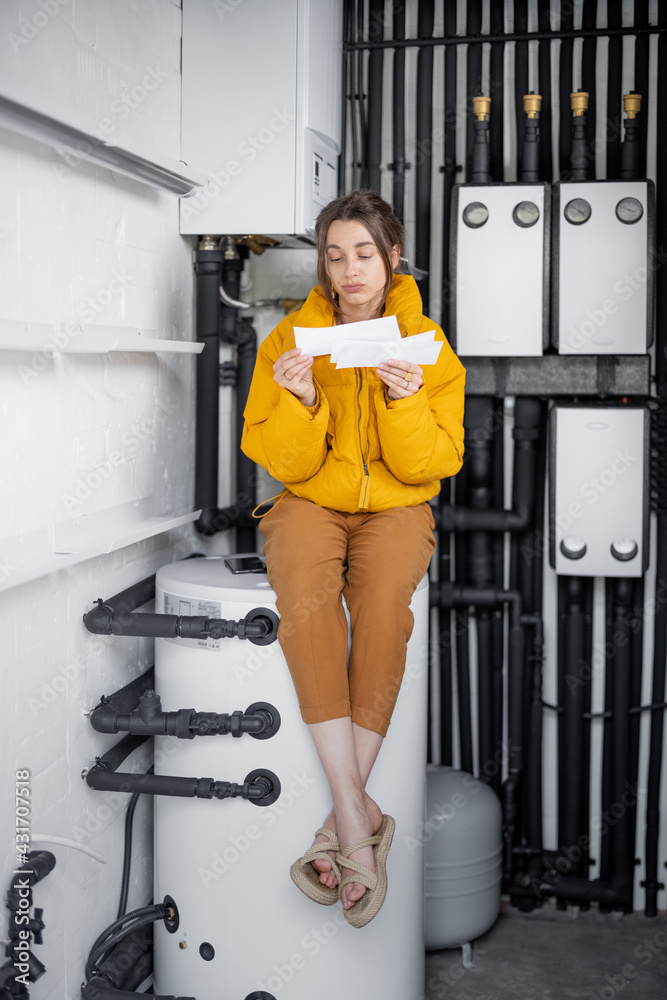 Confused woman looks at electricity bills, comparing data with the meter in the electrical panel at 