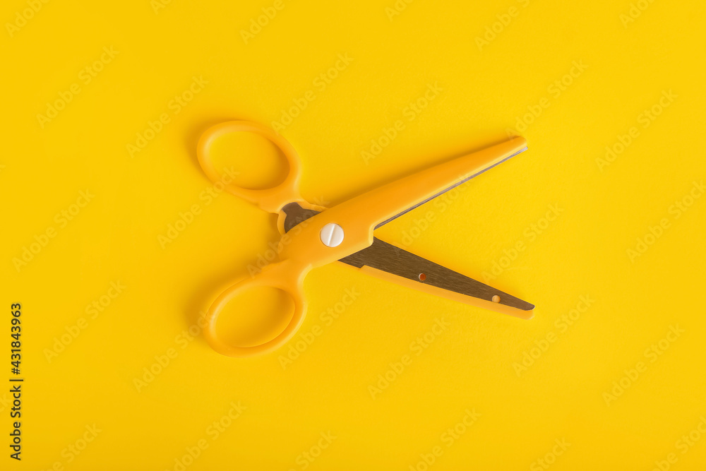 Stylish scissors on color background