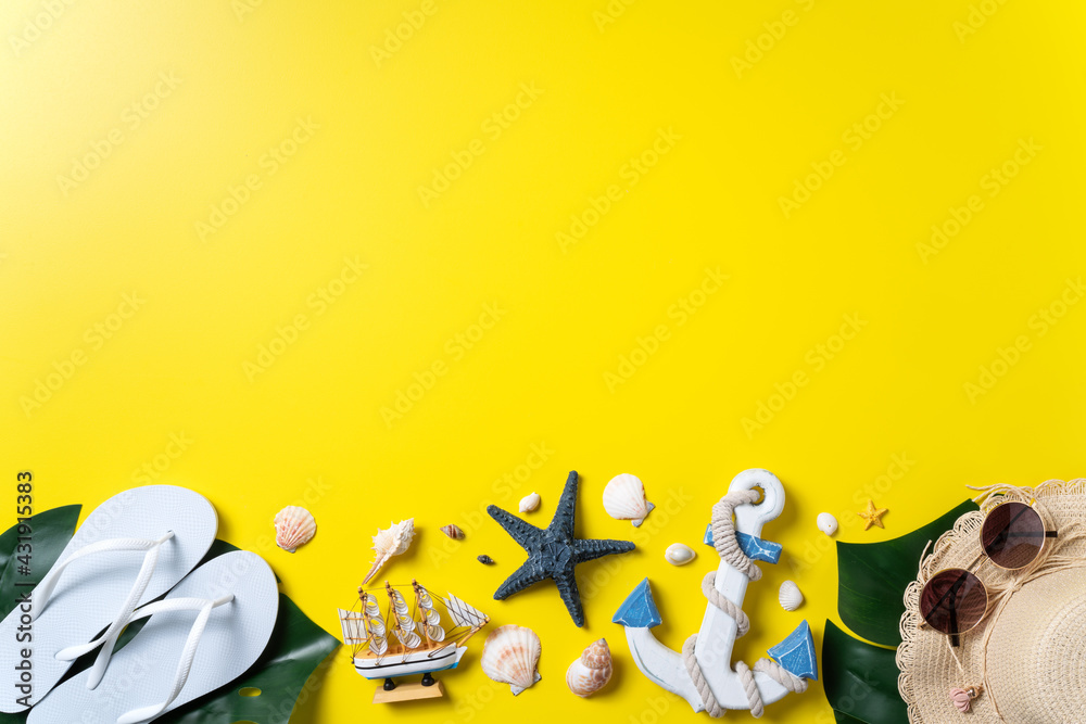 Summer beach design concept with shells, hat, slipper on yellow background.