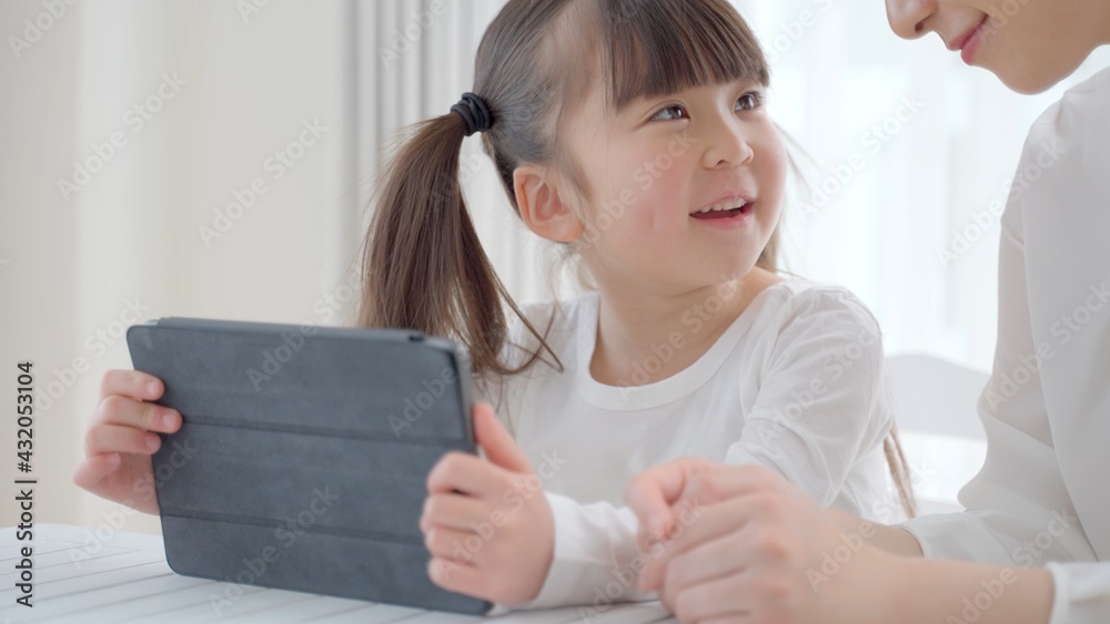 タブレットを使う女の子とお母さん