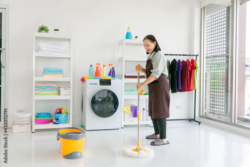 Senior asian woman mopping the floor at home.