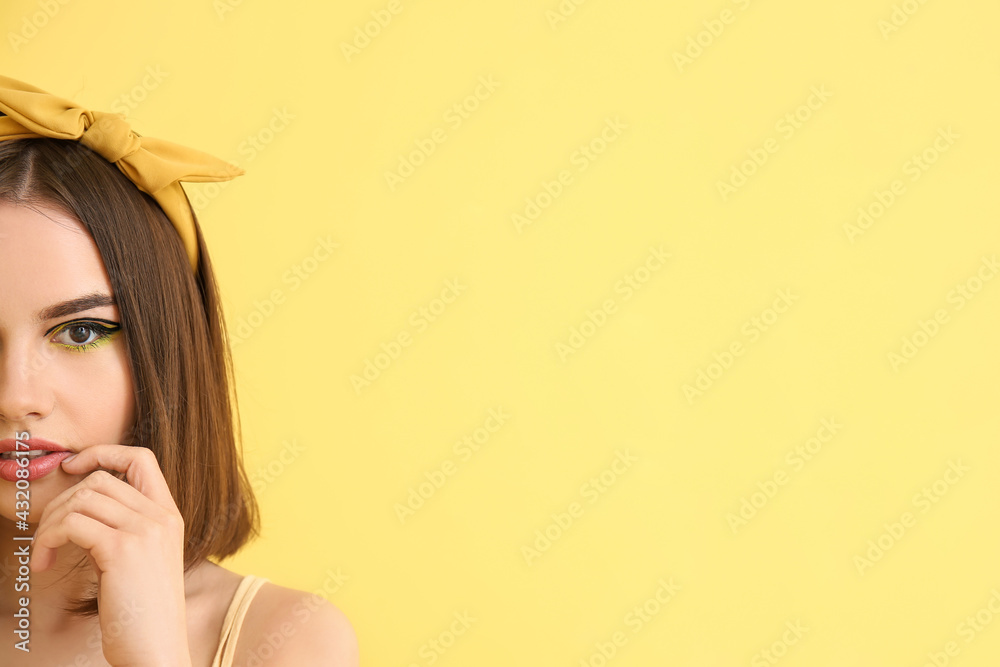 Stylish young woman on yellow background