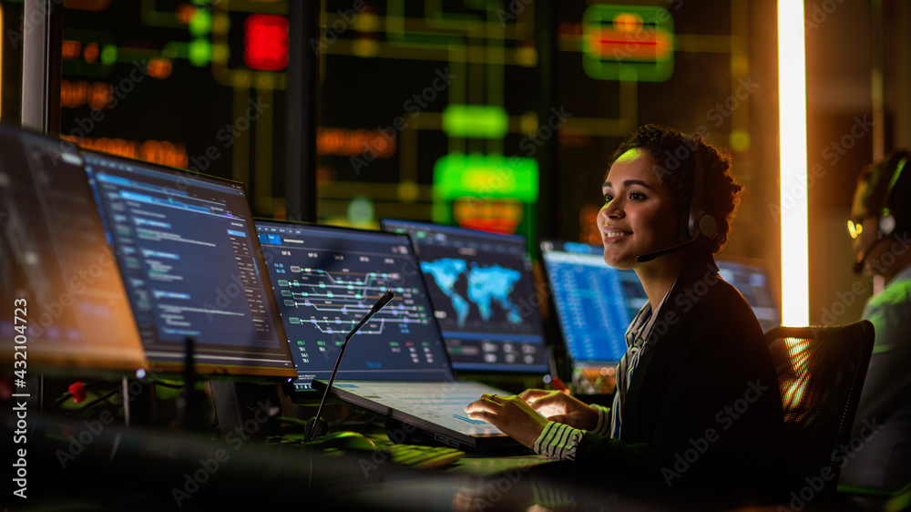 Multiethnic Female IT Technical Support Specialist Talking with a Client in Headphones and Working o