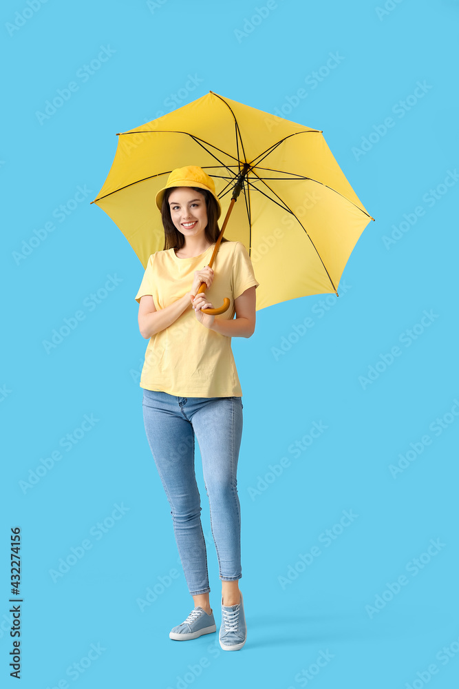 Stylish young woman with umbrella on color background