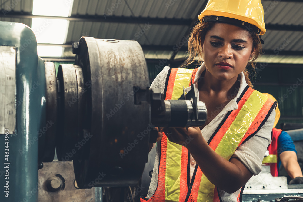 Skillful factory woman worker do machine job in manufacturing workshop . Industrial people and manuf