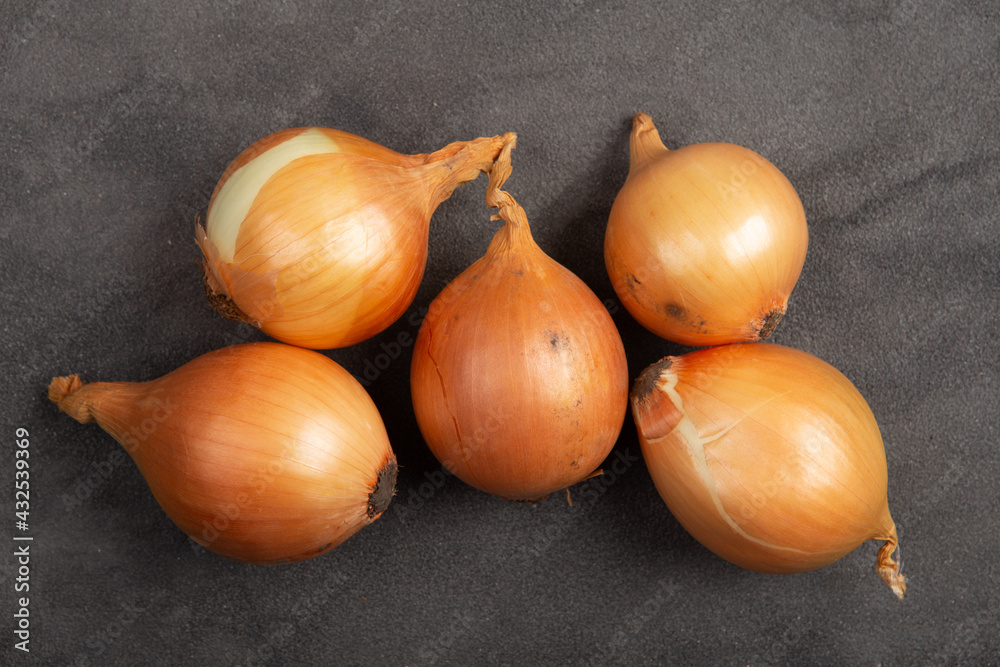 Fresh organiс onions on grey concrete background. Vegetables. Healthy food concept