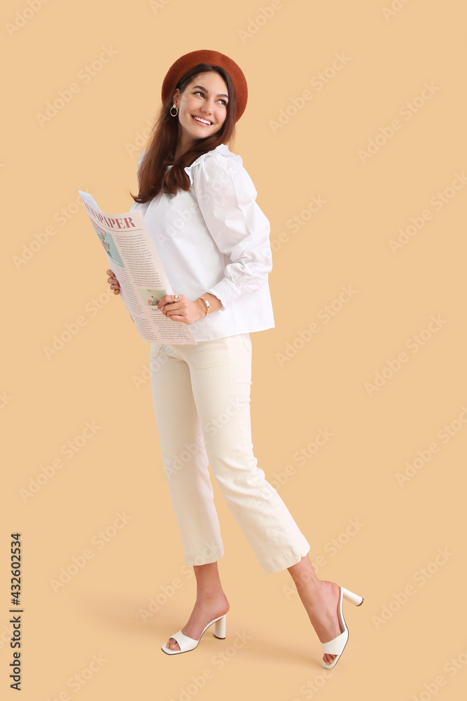 Young woman with newspaper on color background