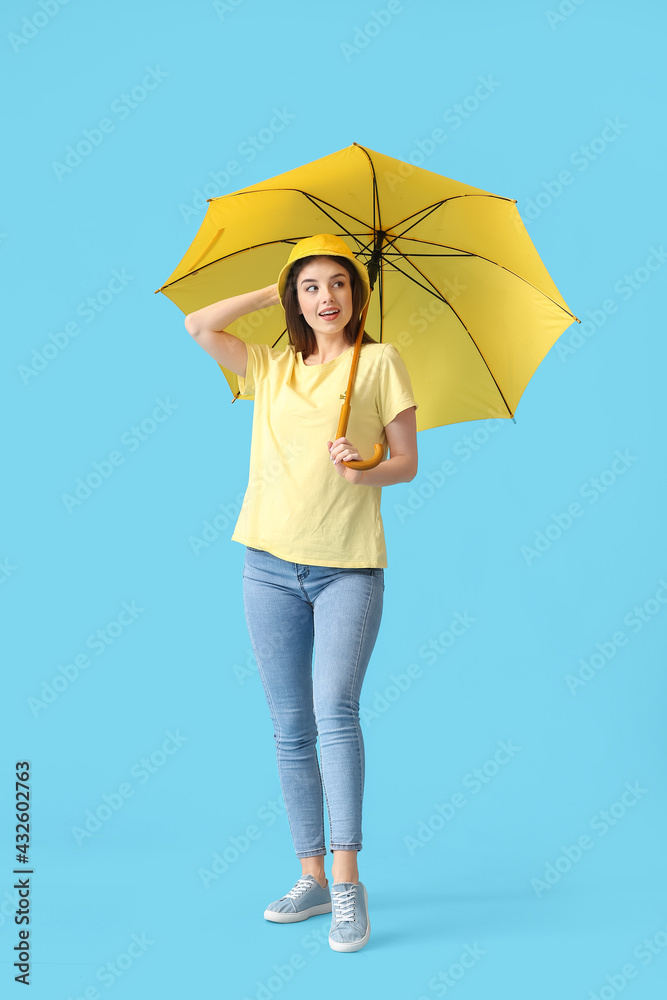 Stylish young woman with umbrella on color background