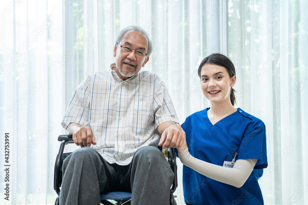 Portrait of old man sitting on wheelchair, nurse sitting beside.