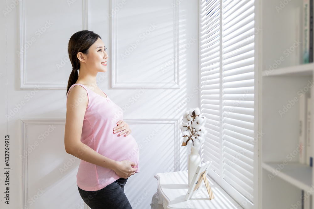 asian pregnant woman near windows