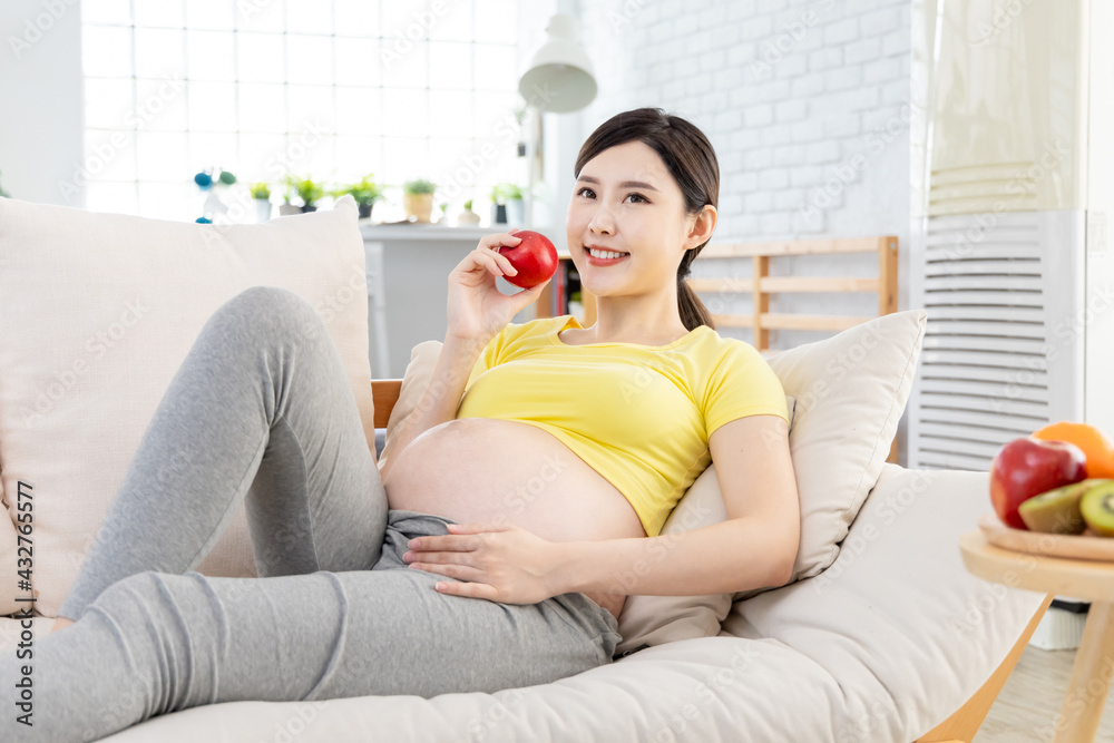 Asian pregnant woman hold fruit