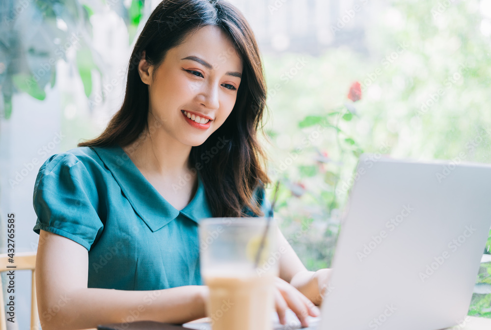 Young Asian woman using laptop at coffee shop