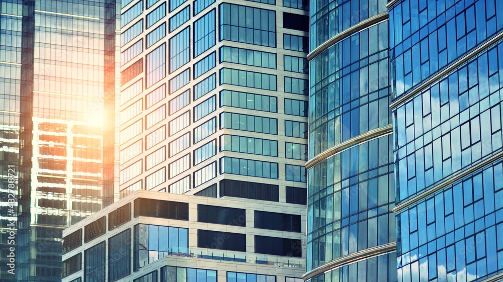 Modern building in the city with sunlight. Abstract texture and blue glass facade in modern office b