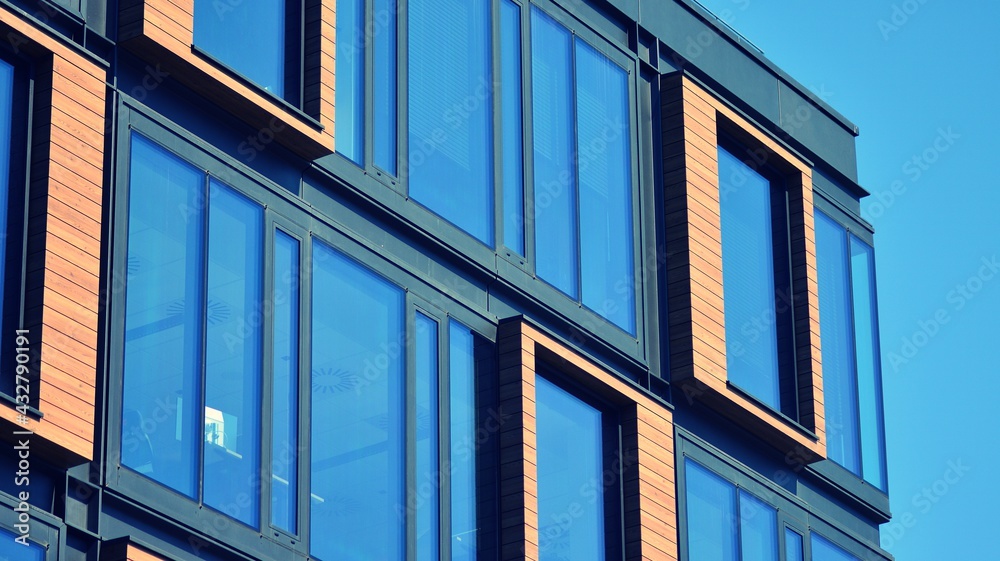 Modern building in the city with sunlight. Abstract texture and blue glass facade in modern office b