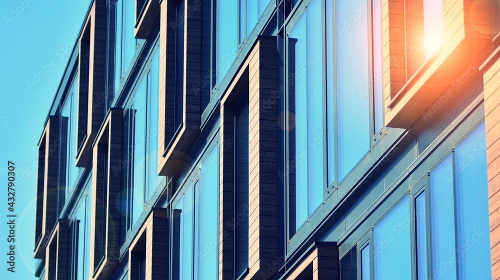 Modern building in the city with sunlight. Abstract texture and blue glass facade in modern office b