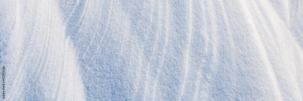 美丽的冬季背景，雪地。自然的雪纹理。风在雪上雕刻图案