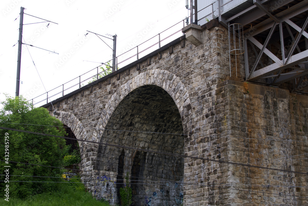 Close-up of iron railway bridge with stone pillars at industrial district at City of Zurich. Photo t