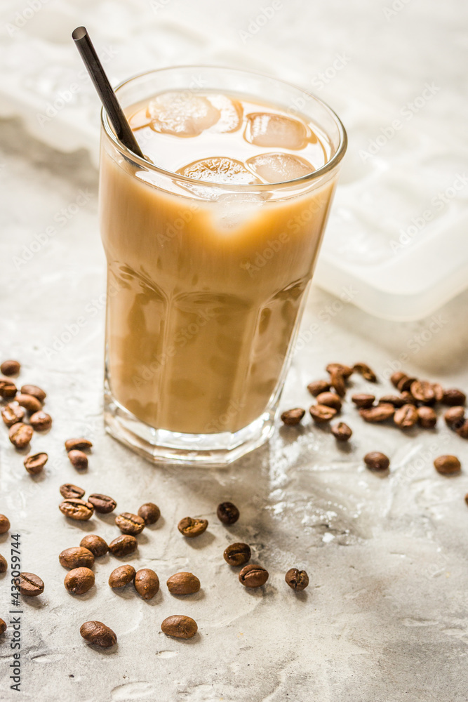 iced coffee with beans for cold summer drink on stone background