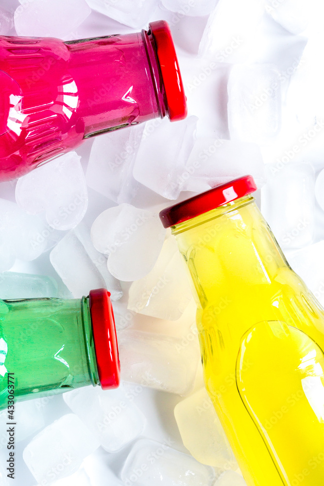 fruit drinks in colorful plastic bottles with ice top view mock-up