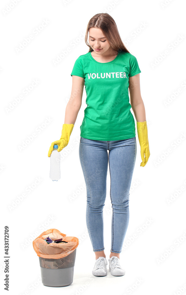 Female volunteer throwing garbage in trash bin on white background