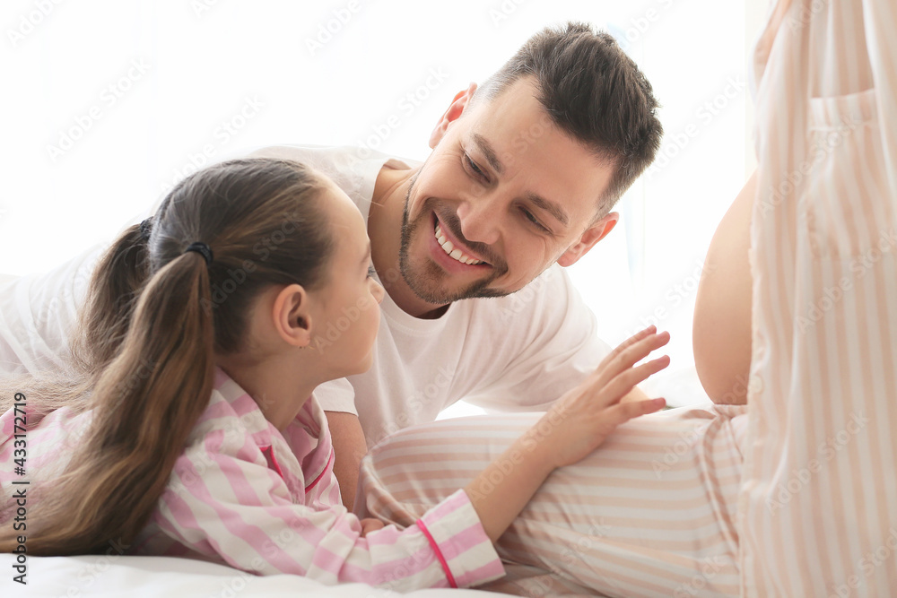 Young pregnant woman with her family at home