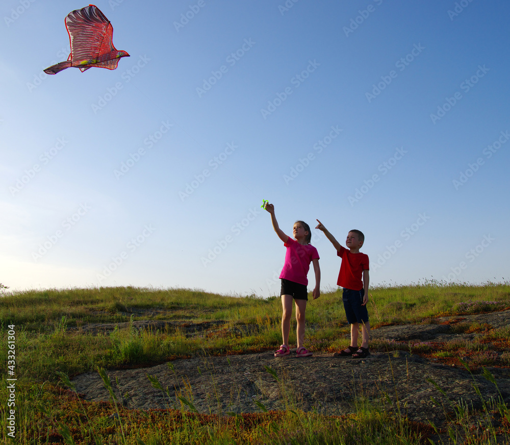 Happy kids boy and girl run with kite