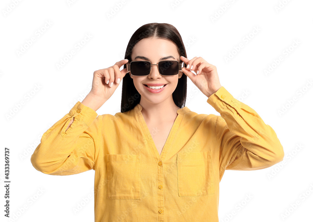 Beautiful young woman wearing stylish sunglasses on white background