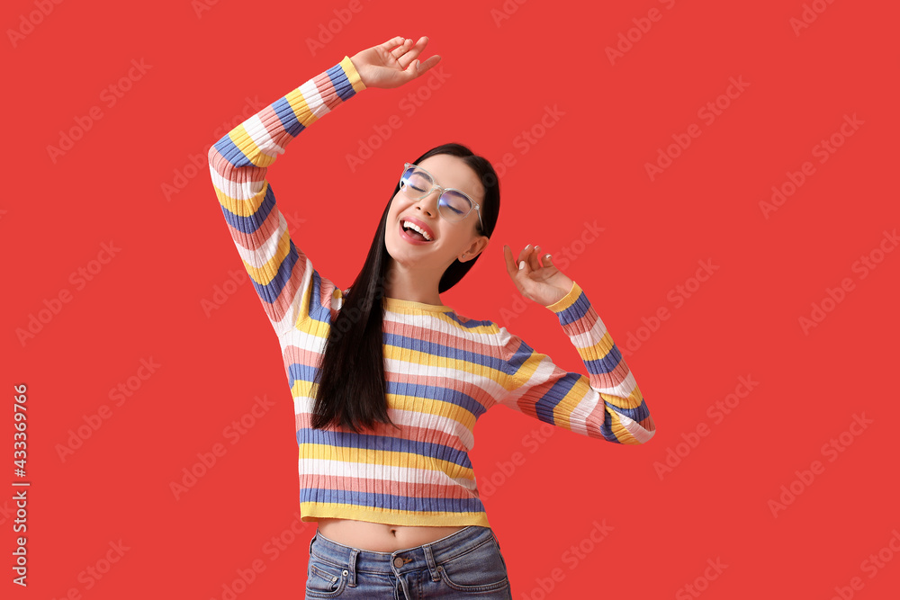 Beautiful young woman wearing eyeglasses on color background