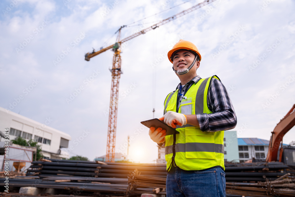 male construction engineer. Architect with a tablet computer at a construction site. Asian young man