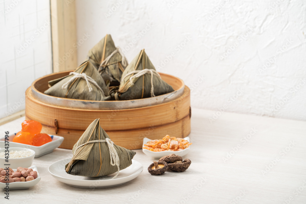 Zongzi. Rice dumpling for Dragon Boat Festival on bright wooden table background with window.